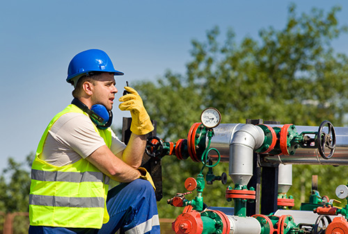 Man talking on radio near a pipeline