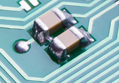 two SMT ceramic capacitors mounted on a circuit board