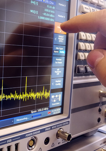 finger pointing to the touch screen of a spectrum analyzer