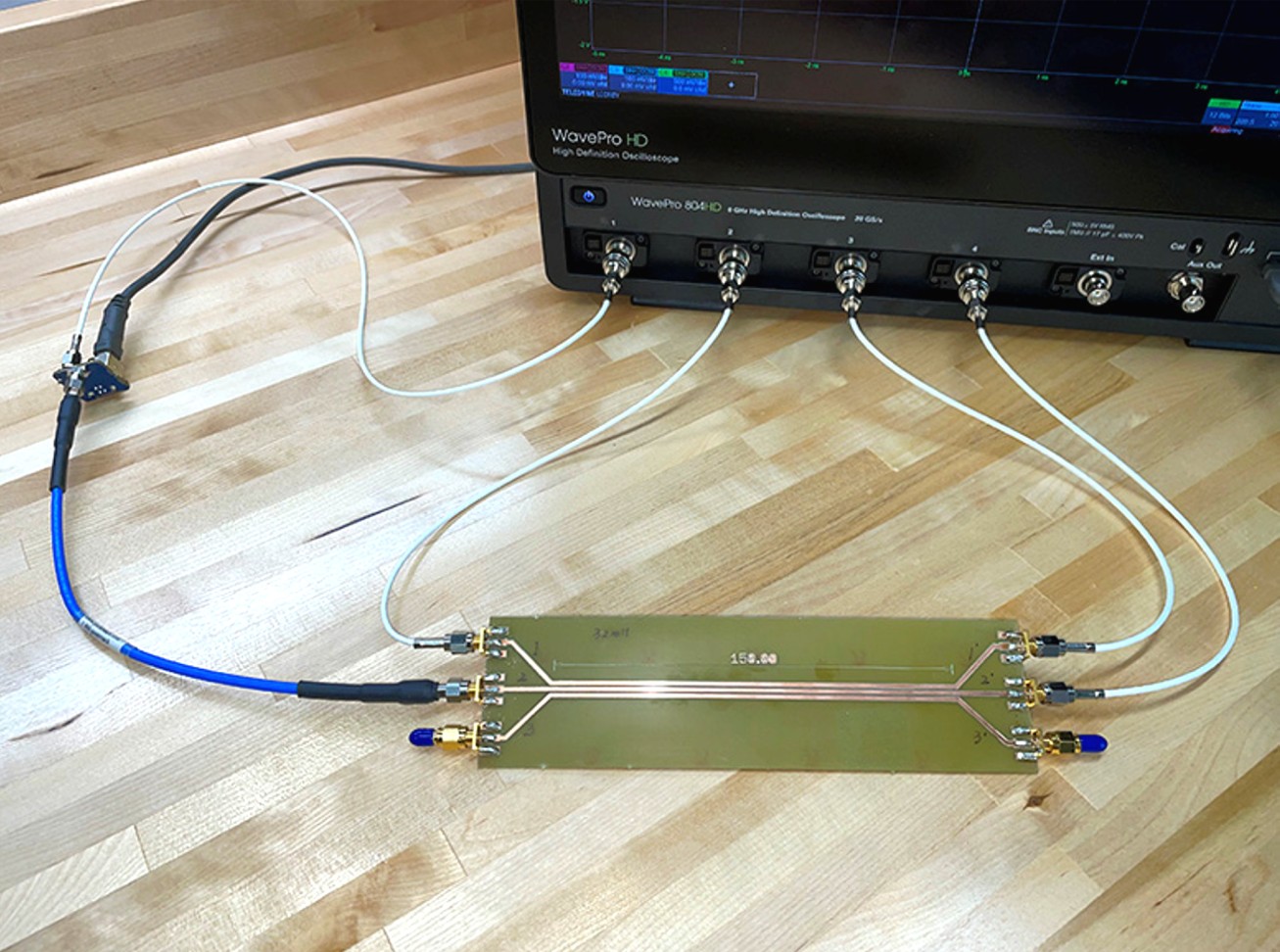 pulse generator and oscilloscope connected to test board with three parallel microstrip traces